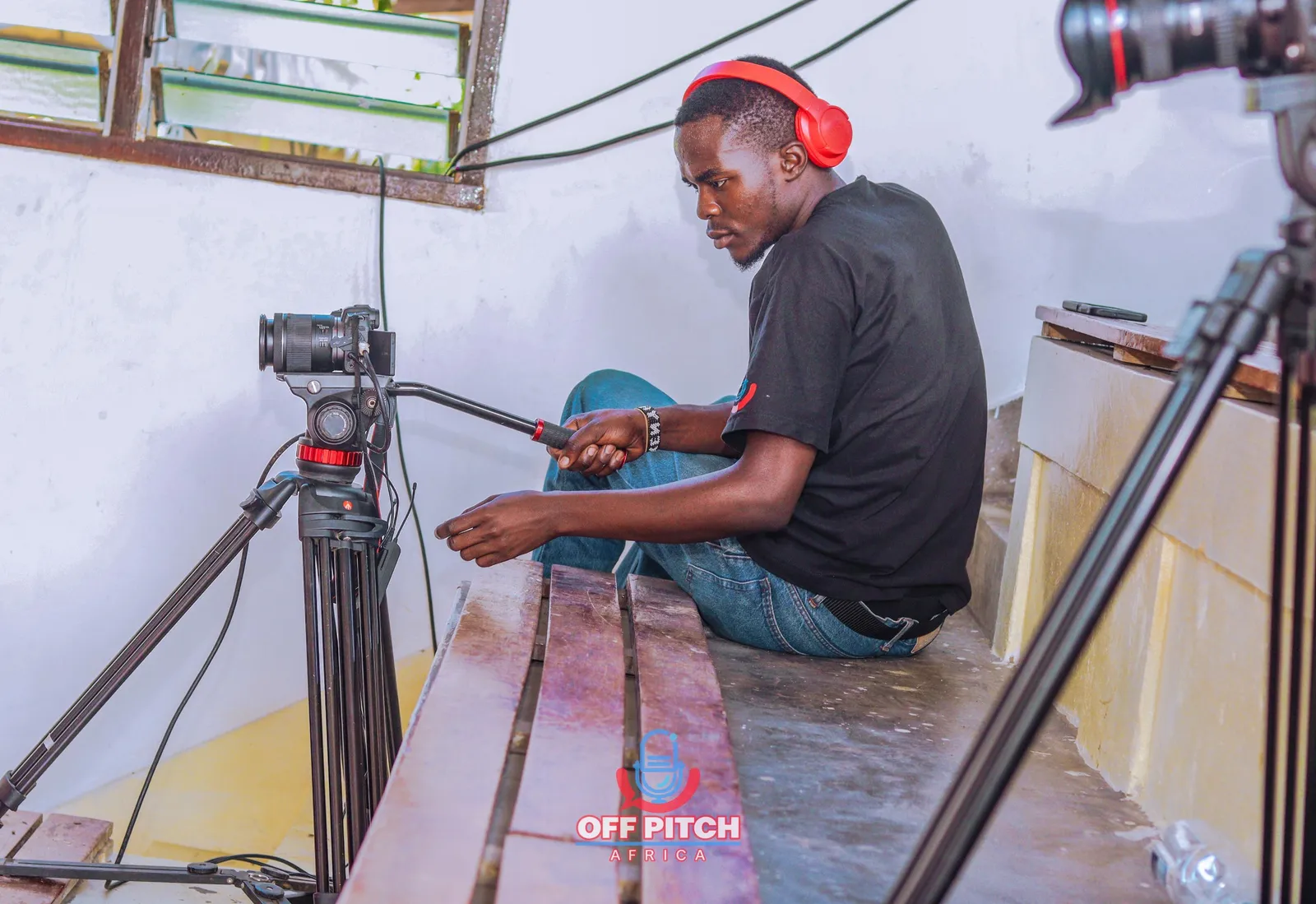 Off Pitch Africa crew member operating a camera on a tripod